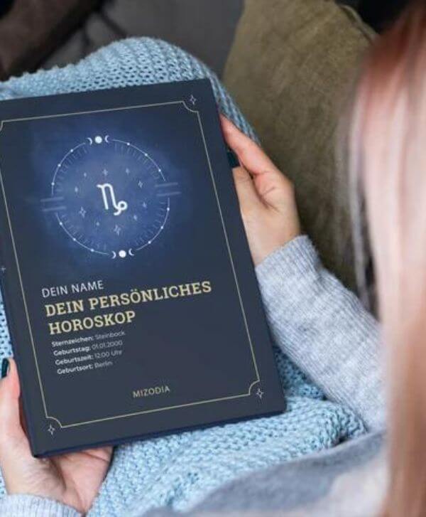 Frau hält das Cover Ihres Horoskopbuchs in den Händen