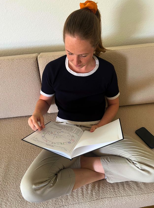 Person hält personalisiertes Horoskopbuch in den Händen